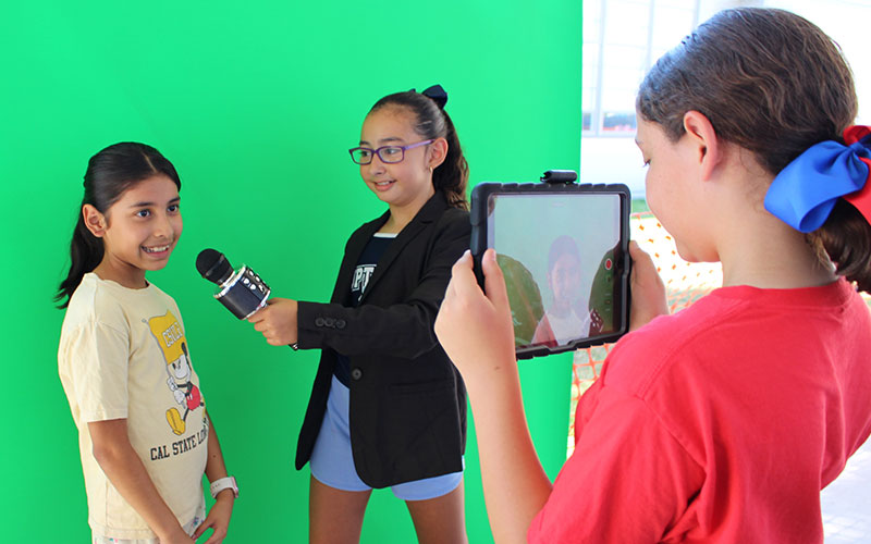 students in front of a green screen