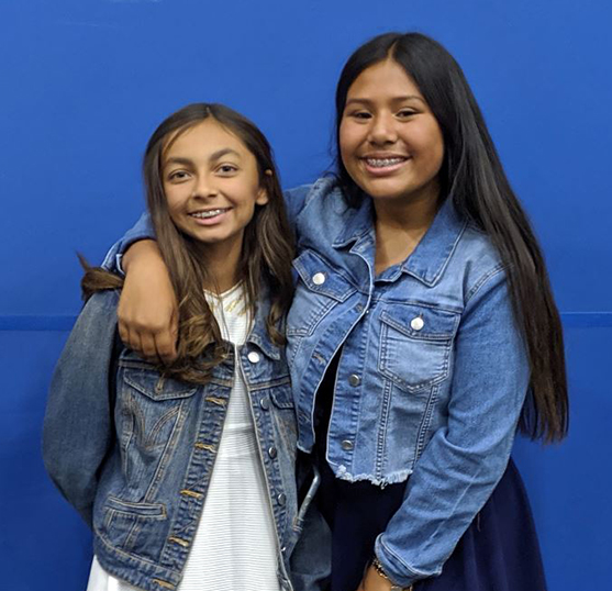 middle school girls working on electronic device