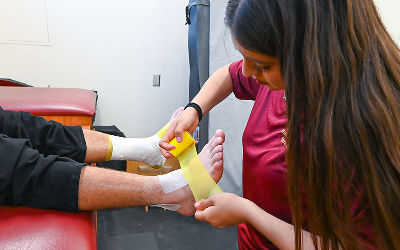 Student bandaging and injured foot