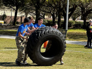 JROTC boot camp team moving a large tire