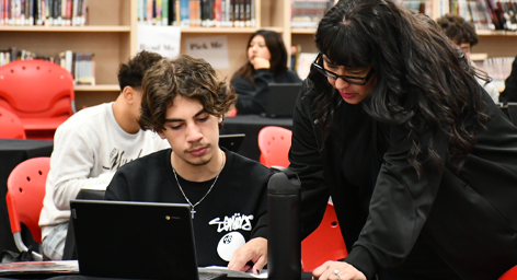 teacher helping student on the laptop