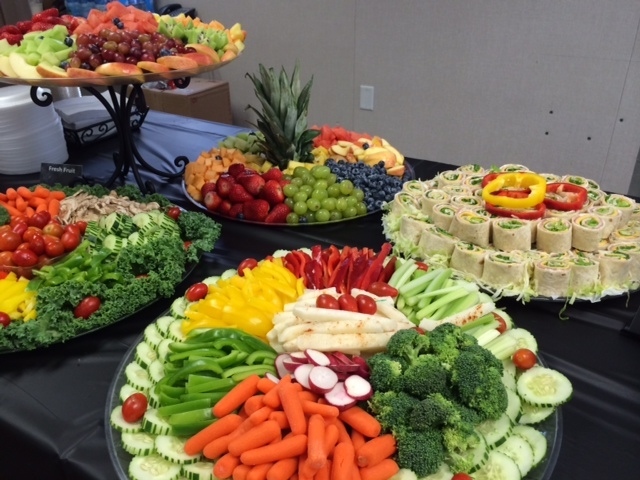 catering trays of sandwiches, fruits, and vegetables
