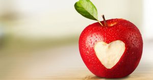 Apple with a heart-shaped bite out of it to represent heart-healthy eating.