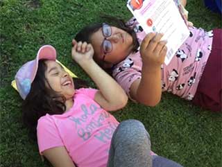 students reading on the grass