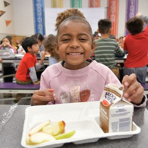 Toddler eating a school lunch