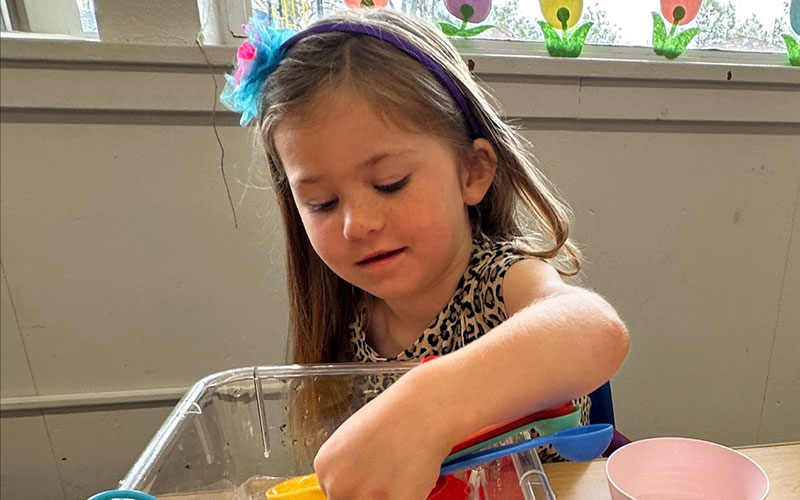 Little girl working on an activity to enhance fine motor skills