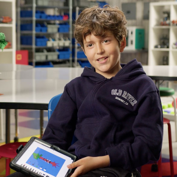 Boy smiling at the camera with an iPad in his hands