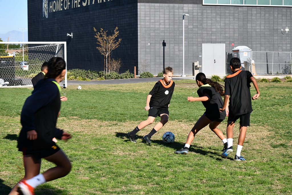 Middle school students playing soccer in the Sports Academy program