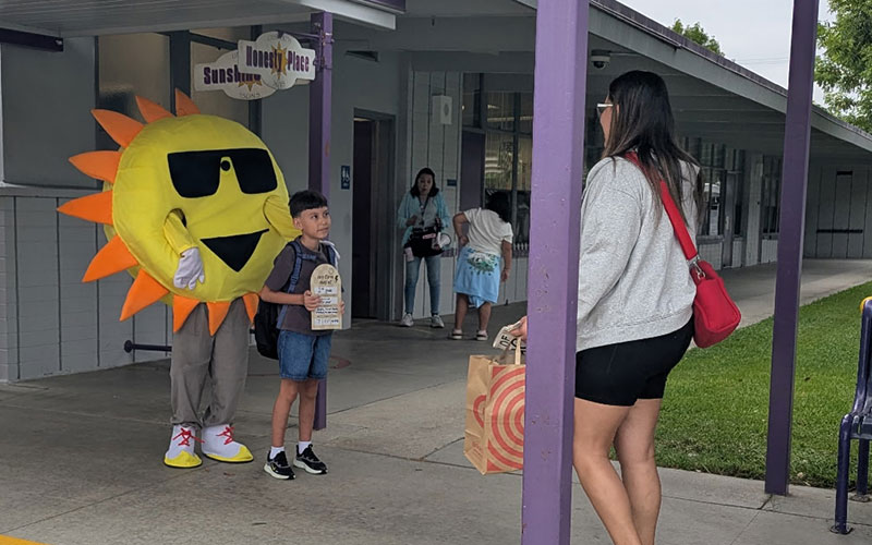 suns mascot with student