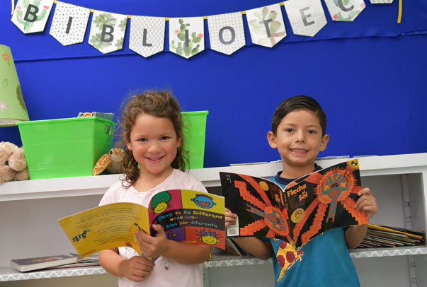 two first grade students reading spanish books