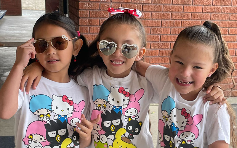 Girls showing off their sunglasses and T-shirts