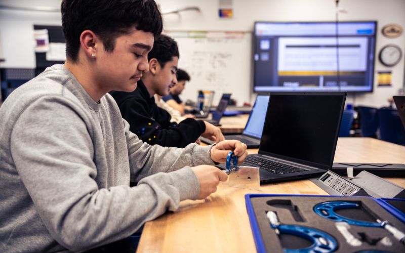 student using calipers for quality control