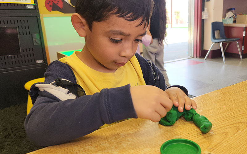 boy manipulating clay