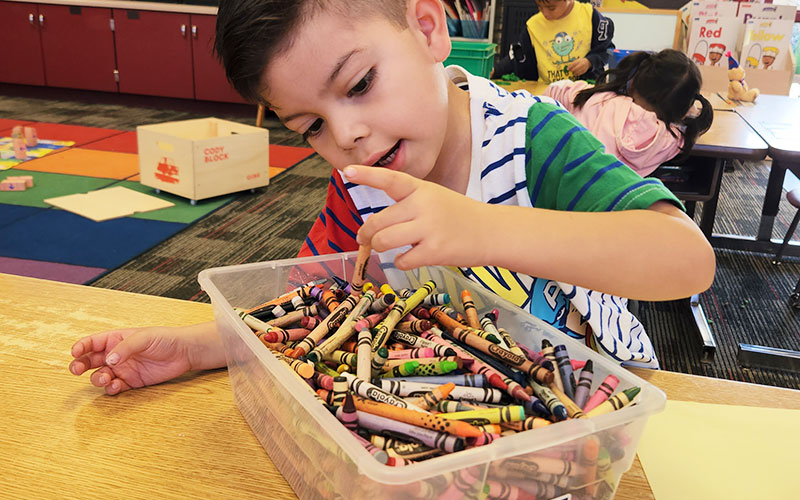 boy with bucket of crayons