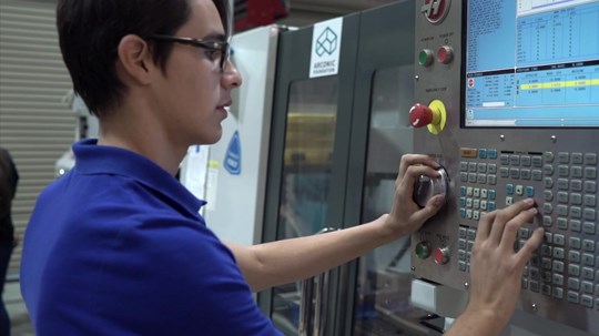 Students operating a machine control panel