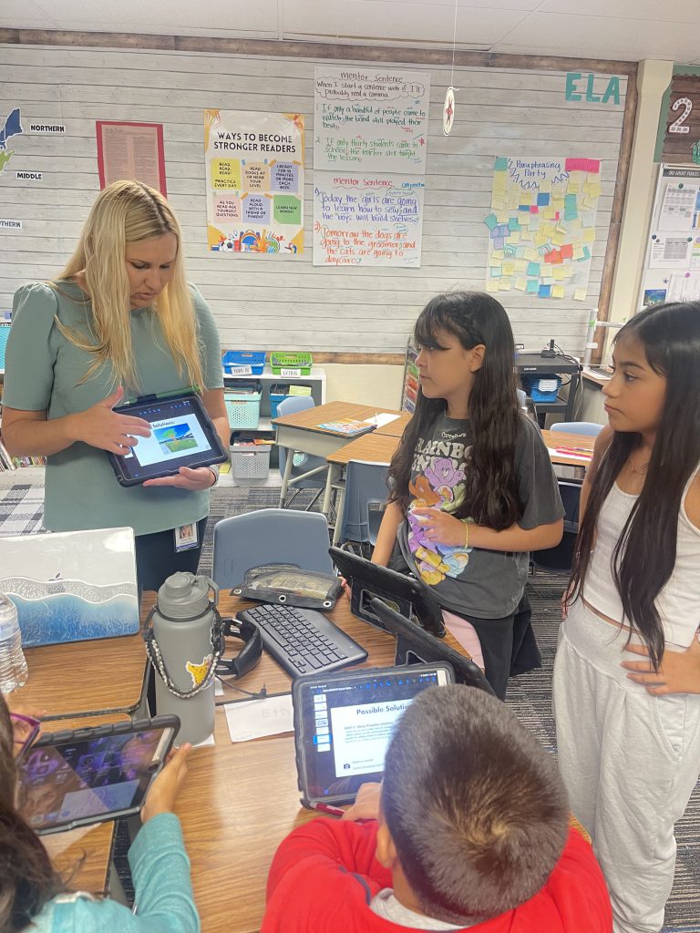 Teacher uses a tablet to teach students in the classroom. 