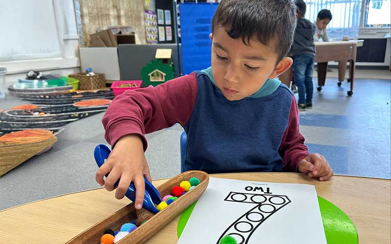 boy practicing activity with fine motor skills