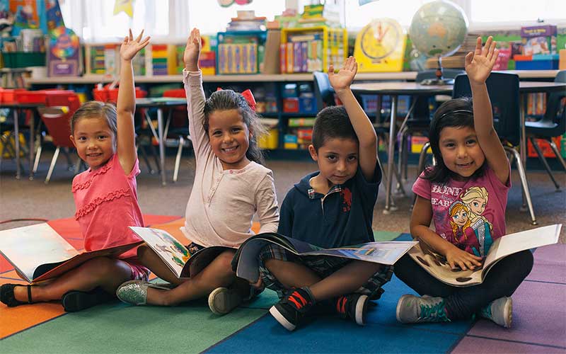 Young students raising their hands
