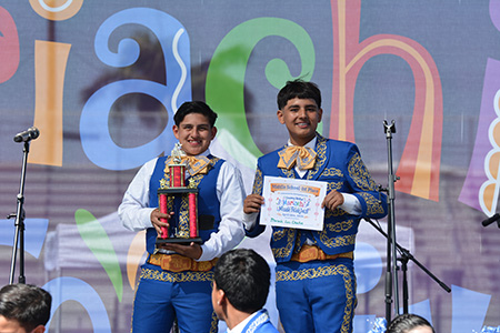 Two middle school students from Downey Unified hold up a third place certificate at the Mariachi Music Festival 2026