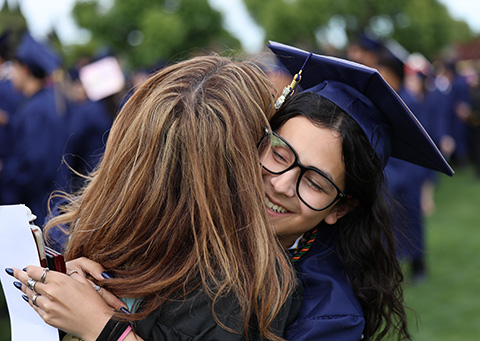 graduate hugging loved one