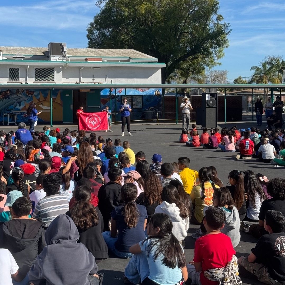 Students gathered at Gauldin Elementary School for a schoolwide Unified Champion Schools assembly as presenters hold a Special Olympics banner at the front.